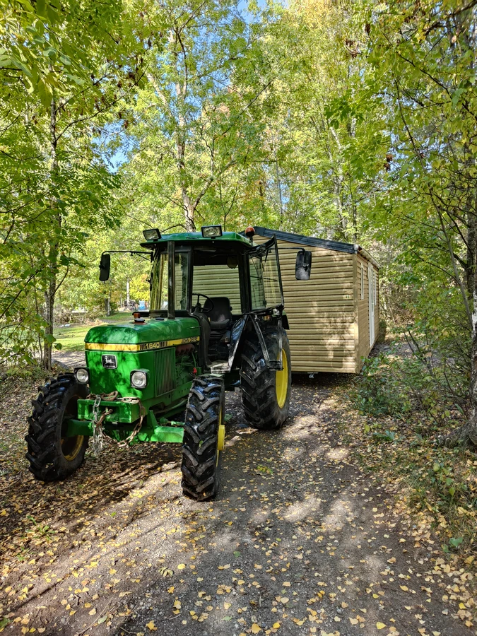Tracteur acheminant un mobil-home en forêt